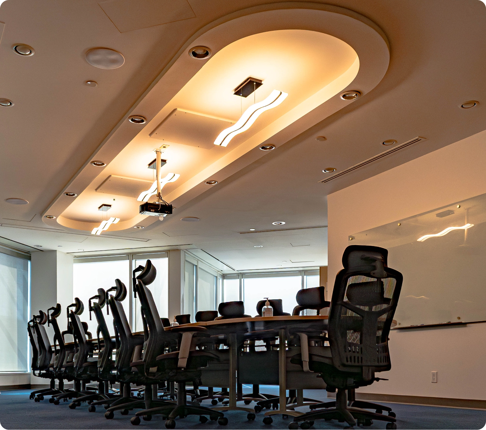 Modern conference room at TCC Canada with a long table, black chairs, and unique lighting fixtures.