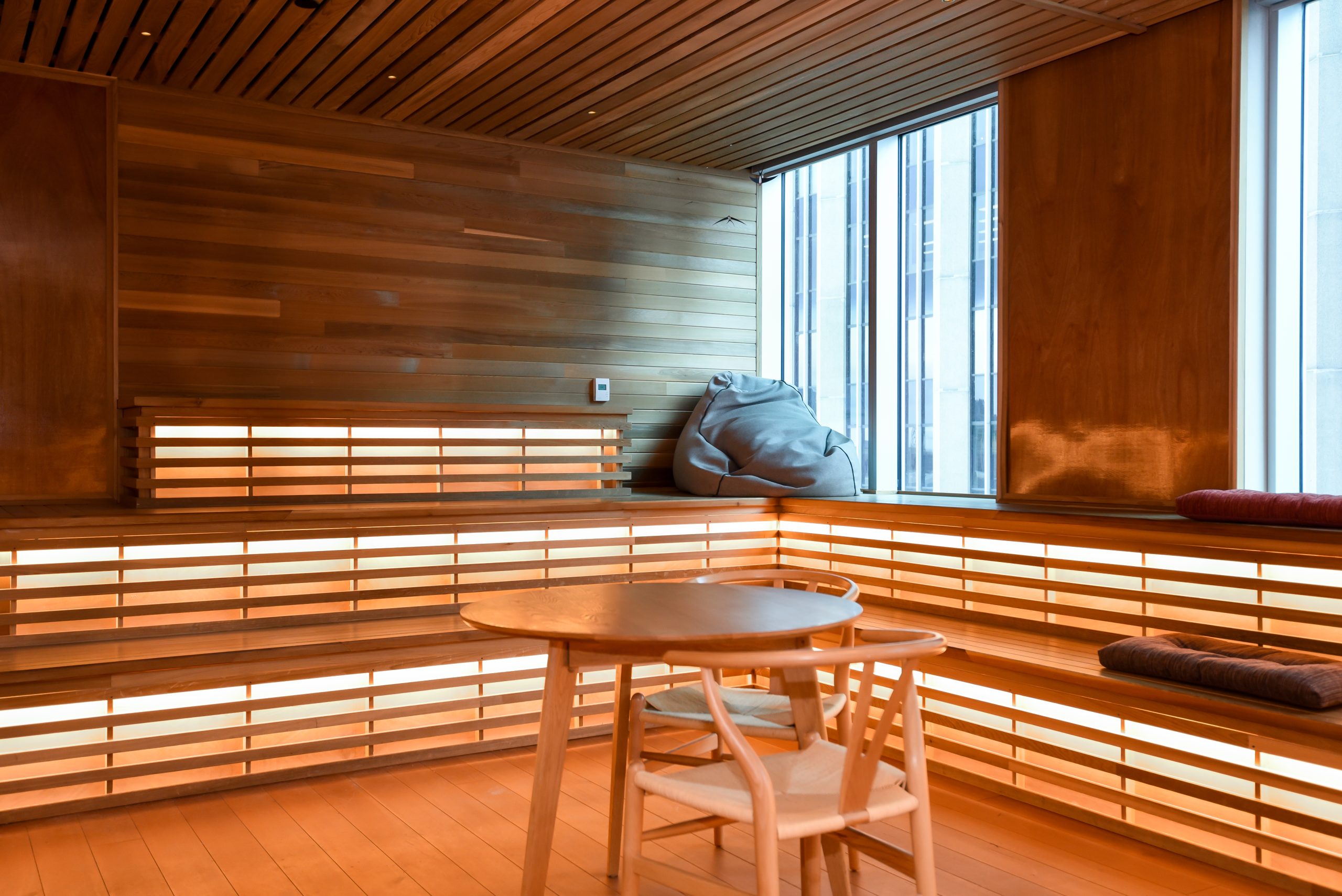 Cozy office nook with wooden walls, built-in seating, and city views.