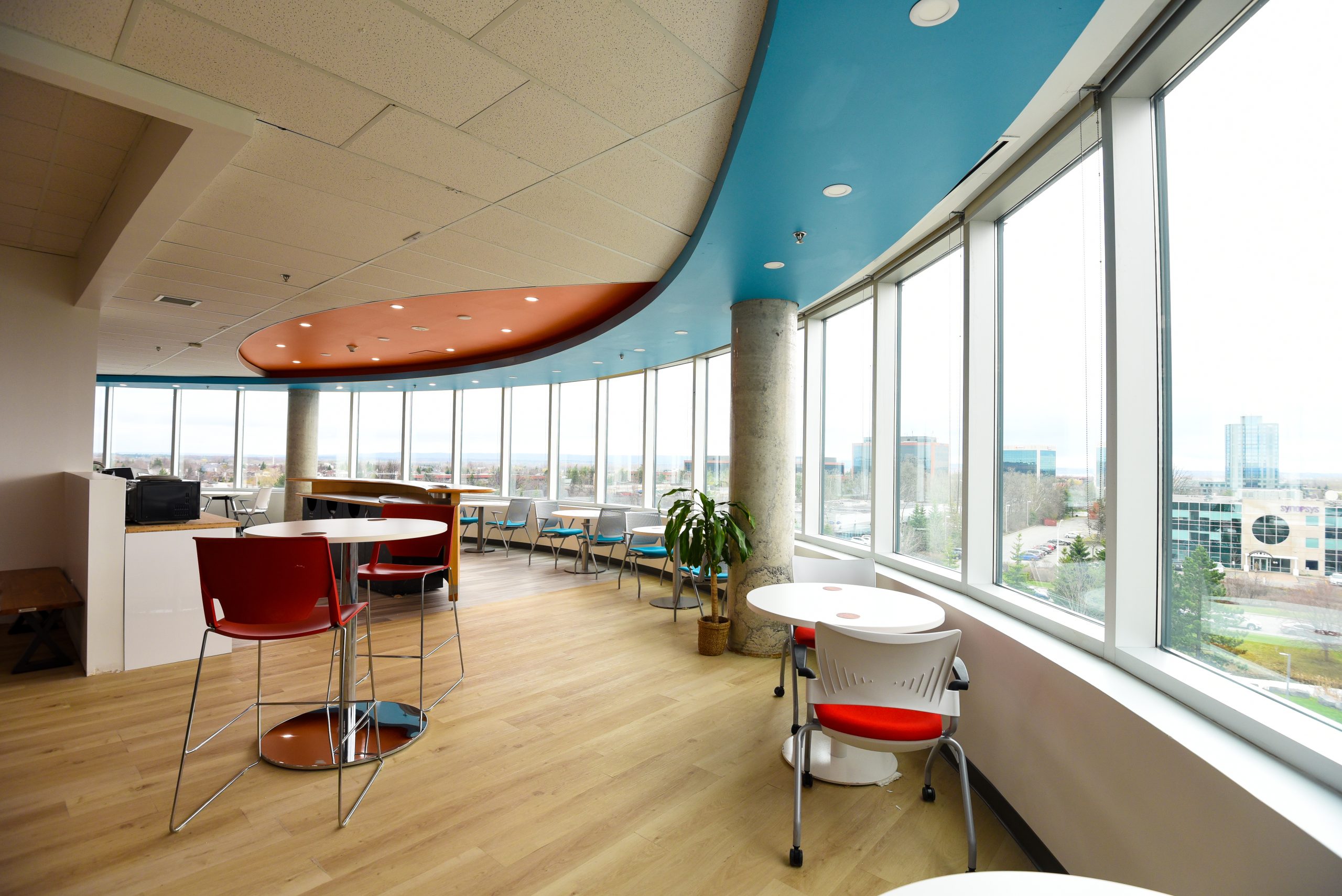 Modern co-working space with city views and colorful accents.