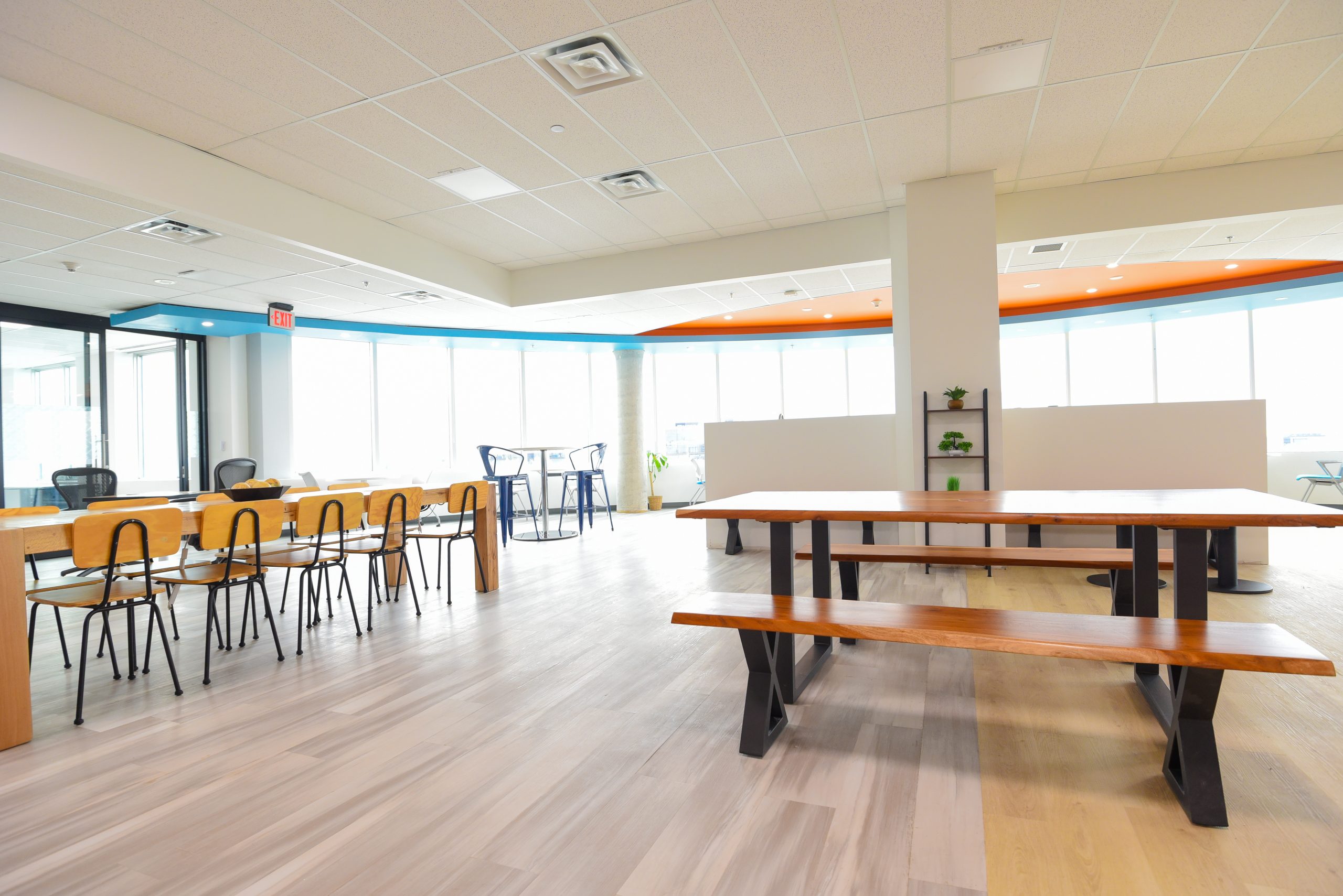 Bright and airy co-working space with wooden tables and benches.
