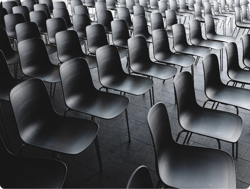 Rows of empty black chairs.
