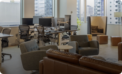 Contemporary office space featuring workstations, comfortable lounge chairs, and expansive city views.