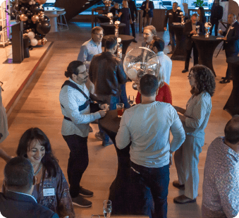 Professionals networking at a modern event, conversing around high-top tables