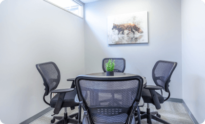 A workspace with a table and four ergonomic chairs