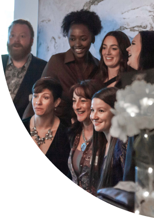 Group of people posing for a photo in a professional setting, smiling and dressed in formal and semi-formal attire.
